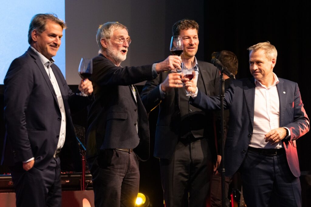Hosts raising a toast on stage at the Festive Evening